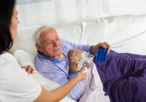 Nurse Helping Senior Man With Medication